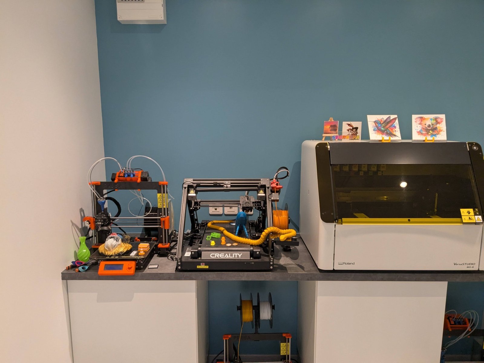 Vue assez rapprochée du fablab avec trois imprimante 3D et l'imprimante a UV à plat.