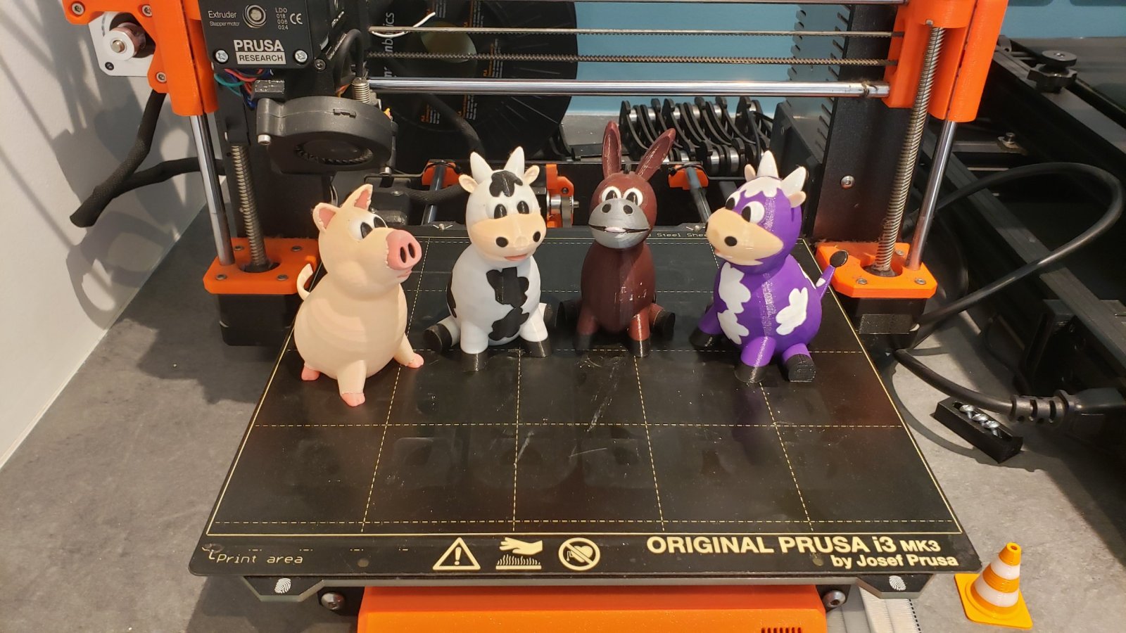 Quatre impressions 3D de figurine en multi couleur, des animaux de la ferme.
